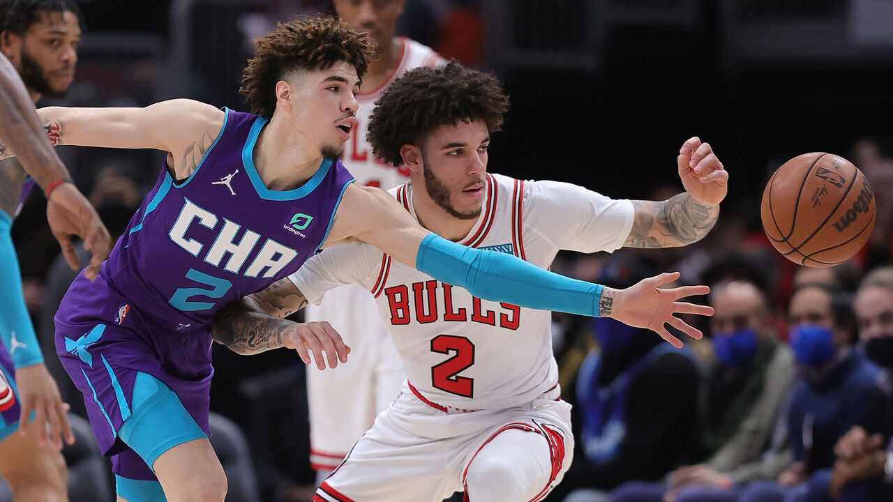 CHICAGO, ILLINOIS - NOVEMBER 29: LaMelo Ball (2) of the Charlotte Hornets and brother Lonzo Ball (2) of the Chicago Bulls chase a loose ball at United Center on November 29, 2021 in Chicago, Illinois.