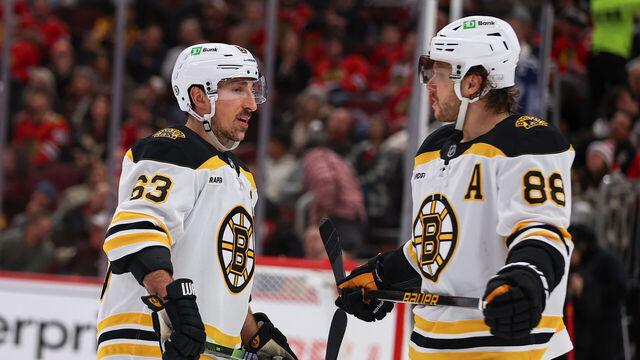 CHICAGO, IL - DECEMBER 04: Brad Marchand #63 of the Boston Bruins and David Pastrnak #88 of the Boston Bruins chat during the third period against the Chicago Blackhawks on December 4, 2024 at the United Center in Chicago, Illinois.