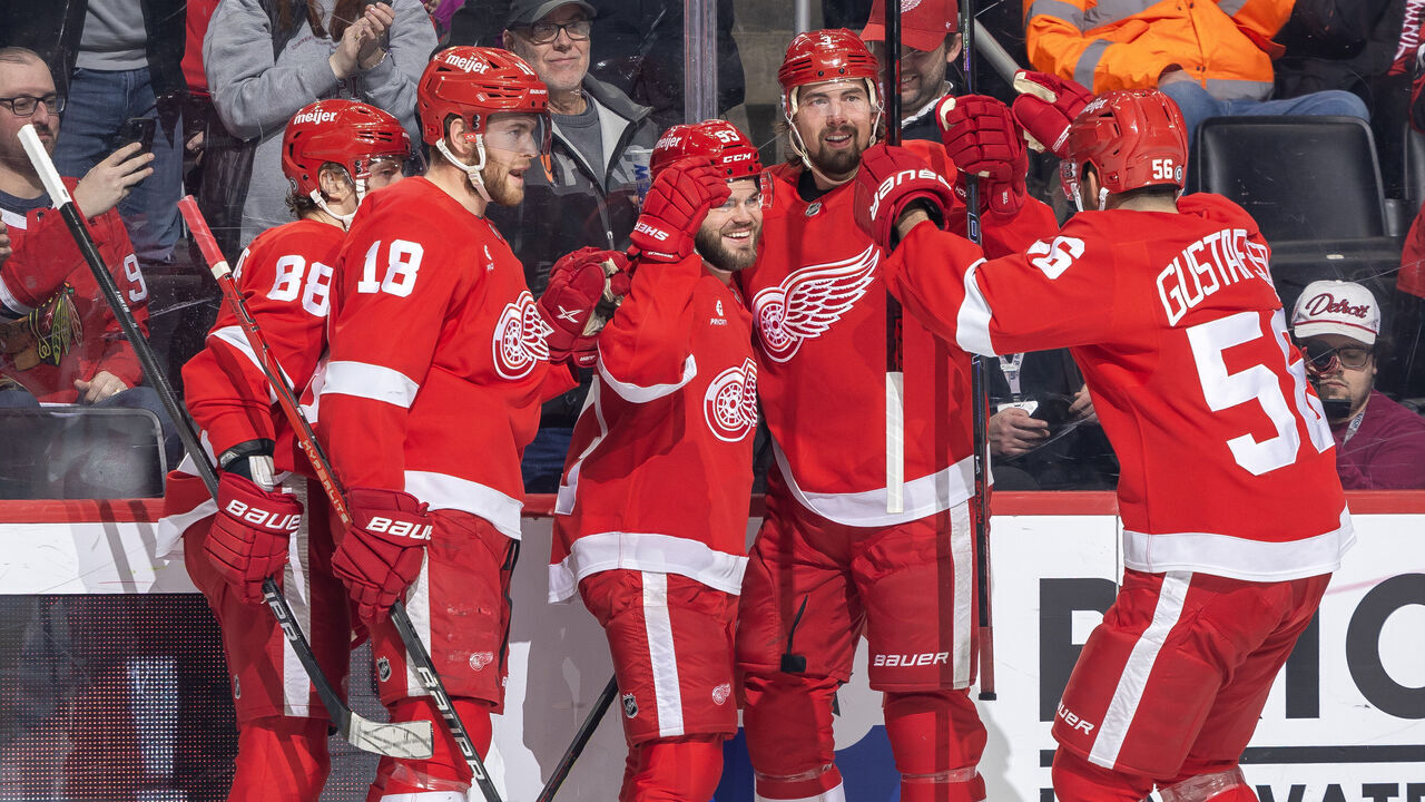 DETROIT, MICHIGAN - JANUARY 10: Alex DeBrincat #93 of the Detroit Red Wings celebrates his goal on Petr Mrazek #34 of the Chicago Blackhawks (not pictured) with teammates during the first period at Little Caesars Arena on January 10, 2024 in Detroit, Michigan.