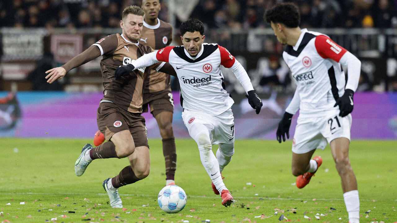 St Pauli's German defender #05 Hauke Wahl (L) and Frankfurt's Egyptian forward #07 Omar Marmoush (C) vie for the ball during the German first division Bundesliga football match between St Pauli and Eintracht Frankfurt in Hamburg on January 11, 2025.