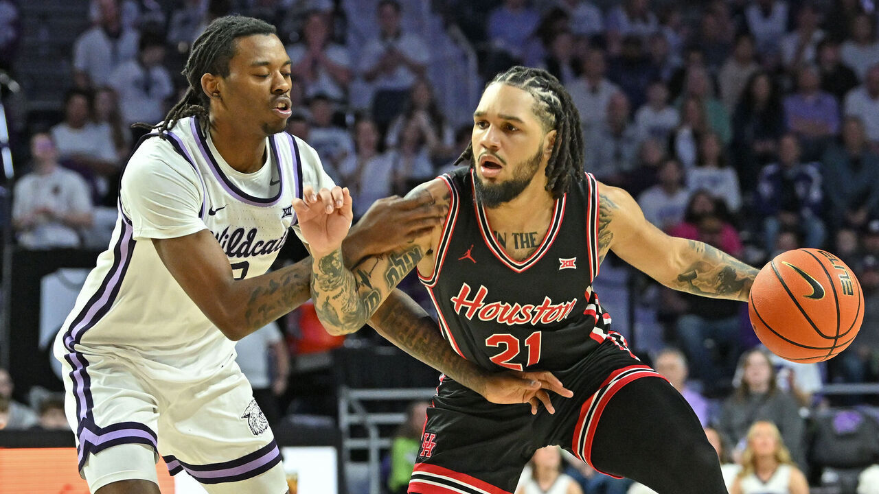 MANHATTAN, KS - JANUARY 11: Emanuel Sharp #21 of the Houston Cougars dribbles the ball against pressure form C.J. Jones #3 of the Kansas State Wildcats in the first half at Bramlage Coliseum on January 11, 2025 in Manhattan, Kansas.