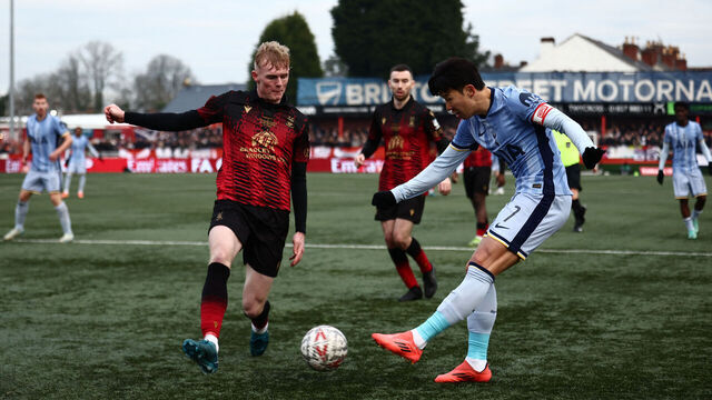 Tottenham Hotspur's South Korean striker #07 Son Heung-Min (R) crosses the ball under pressure from Tamworth's English defender #33 Ben Crompton (L) during the English FA Cup third round football match between Tamworth and Tottenham Hotspur at The Lamb Ground in Tamworth, central England on January 12, 2025.
