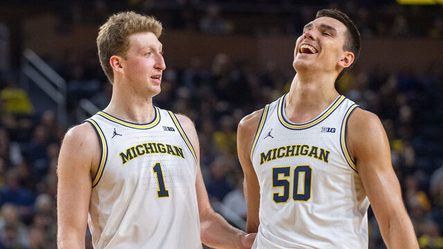 ANN ARBOR, MICHIGAN - JANUARY 12: Danny Wolf #1 (L) and Vladislav Goldin #50 of the Michigan Wolverines chat on the court during a break in the action of the second half of a college basketball game against the Washington Huskies at Crisler Arena on January 12, 2025 in Ann Arbor, Michigan. The Michigan Wolverines won the game 91-75.
