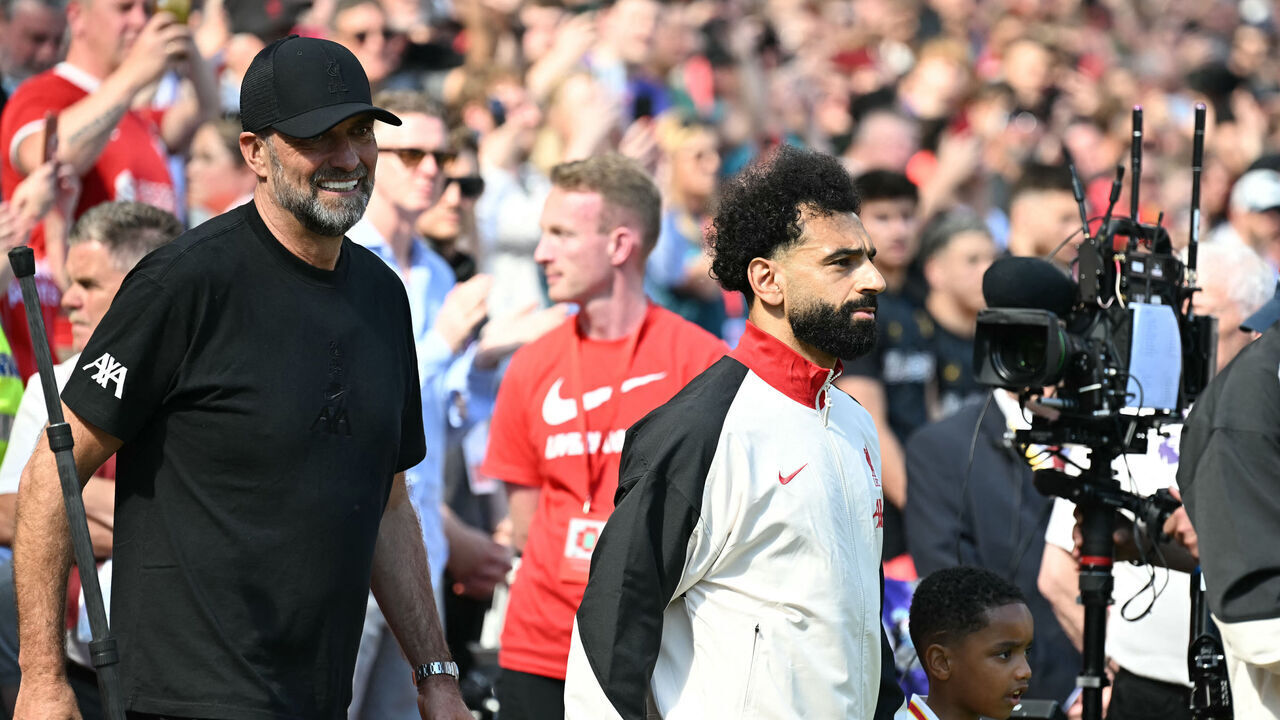 Liverpool's German manager Jurgen Klopp (L) walks out with Liverpool's Egyptian striker #11 Mohamed Salah (C) ahead of kick-off in the English Premier League football match between Liverpool and Wolverhampton Wanderers at Anfield in Liverpool, north west England on May 19, 2024. Jurgen Klopp said Friday he has experienced the "most intense" week of his life as he prepares to bring down the curtain on his trophy-filled Liverpool reign. Klopp, who arrived at the club in October 2015, won seven major trophies at Liverpool, including the club's first league title for 30 years and the 2019 Champions League.