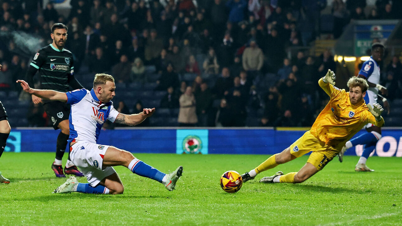 BLACKBURN, ENGLAND - JANUARY 15: Blackburn Rovers' Andreas Weimann scores his side's third goal despite the attentions of Portsmouth's Nicolas Schmid during the Sky Bet Championship match between Blackburn Rovers FC and Portsmouth at Ewood Park on January 15, 2025 in Blackburn, England.