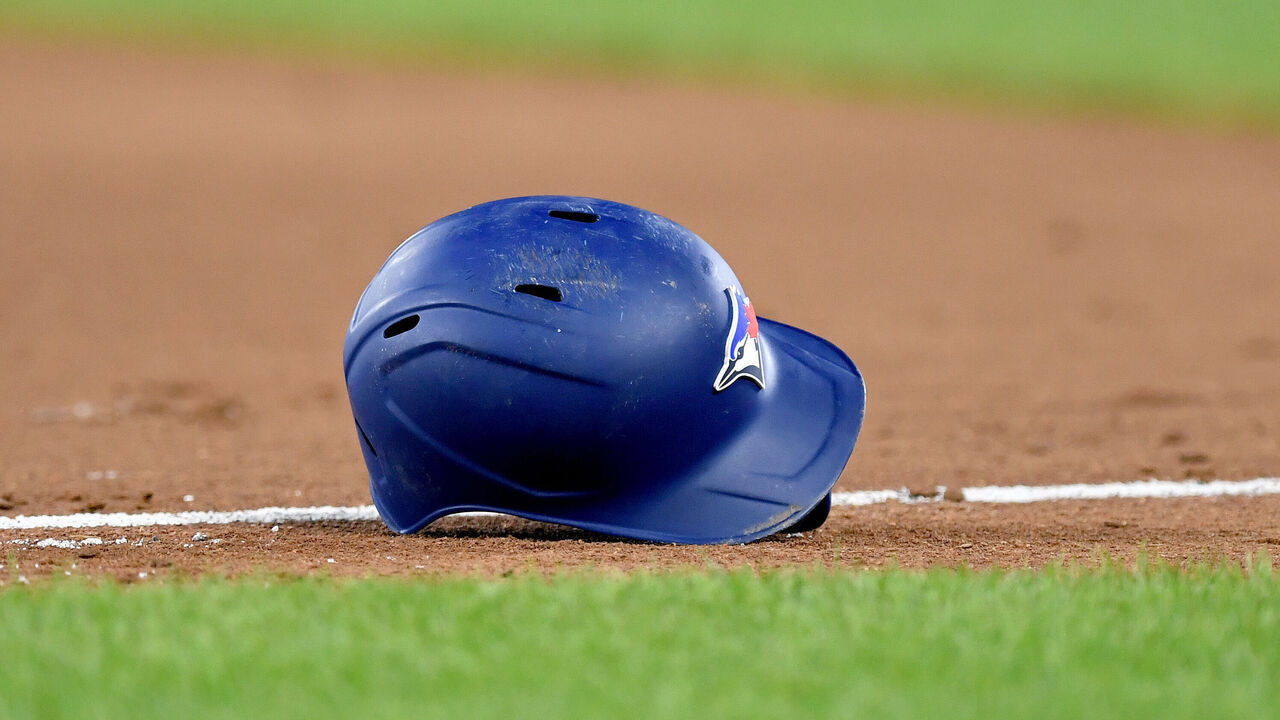 BALTIMORE, MD - AUGUST 23: A close up view of a Toronto Blue Jays bird logo on a batting helmet on the infield dirt with natural turf grass during the Toronto Blue Jays versus Baltimore Orioles MLB game at Orioles Park at Camden Yards on Aug 23, 2023 in Baltimore, MD.