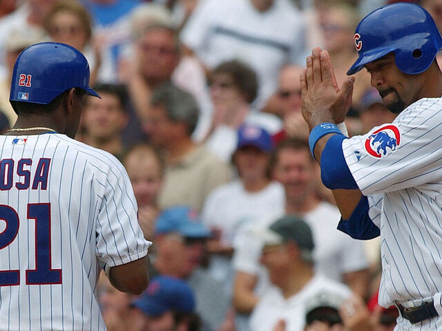CHICAGO - AUGUST 26: Sammy Sosa #21 of the Chicago Cubs is greeted by teammates Nomar Garciaparra #5 (L) and Derrek Lee #25 after hitting a three-run home run in the third inning against the Houston Astros on August 26, 2004 at Wrigley Field in Chicago, Illinois. The Cubs defeated the Astros 8-3.