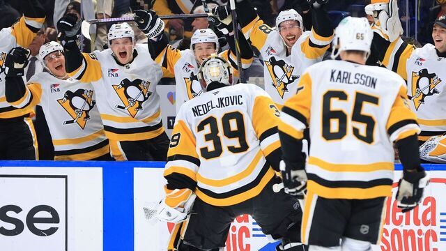 BUFFALO, NEW YORK - JANUARY 17: Goaltender Alex Nedeljkovic #39 of the Pittsburgh Penguins celebrates with teammates on the bench after scoring an empty net goal during an NHL game against the Buffalo Sabres on January 17, 2025 at KeyBank Center in Buffalo, New York.