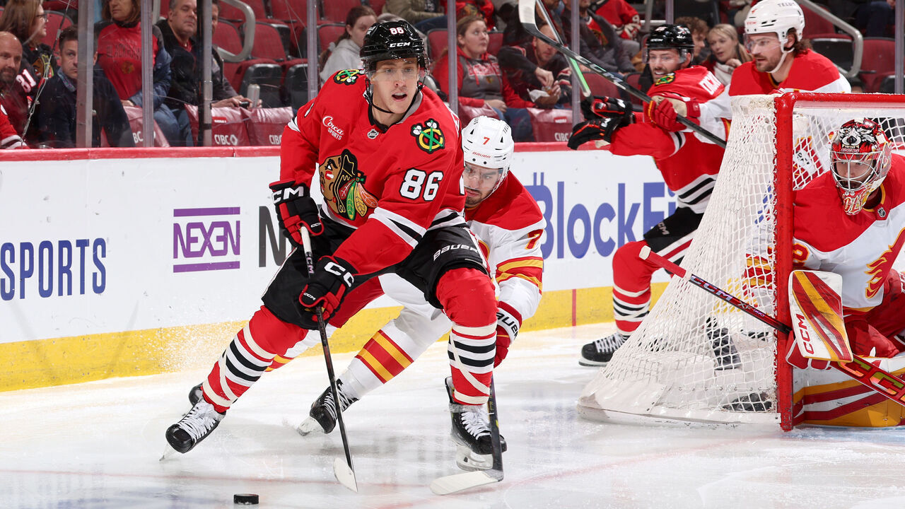 CHICAGO, ILLINOIS - JANUARY 13: Teuvo Teravainen #86 of the Chicago Blackhawks approaches the puck ahead of Kevin Bahl #7 of the Calgary Flames in the second period at the United Center on January 13, 2025 in Chicago, Illinois.