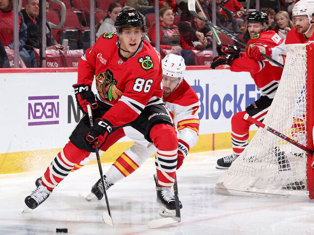 CHICAGO, ILLINOIS - JANUARY 13: Teuvo Teravainen #86 of the Chicago Blackhawks approaches the puck ahead of Kevin Bahl #7 of the Calgary Flames in the second period at the United Center on January 13, 2025 in Chicago, Illinois.