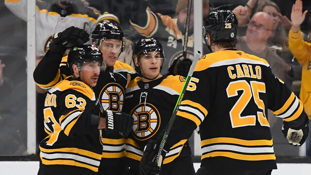 BOSTON, MASSACHUSETTS - JANUARY 20: Brad Marchand #63, Charlie Coyle #13, Matthew Poitras #51 and Brandon Carlo #25 of the Boston Bruins celebrate the third-period goal against the San Jose Sharks on January 20, 2025, at the TD Garden in Boston, Massachusetts.
