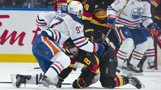 VANCOUVER, CANADA - JANUARY 18: Connor McDavid #97 of the Edmonton Oilers checks Conor Garland #8 of the Vancouver Canucks during the third period of their NHL game at Rogers Arena on January 18, 2025 in Vancouver, British Columbia, Canada. Vancouver won 3-2.