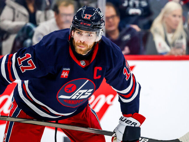 WINNIPEG, CANADA - JANUARY 18: Adam Lowry #17 of the Winnipeg Jets looks on as he get set to take a third period face-off against the Calgary Flames at the Canada Life Centre on January 18, 2025 in Winnipeg, Manitoba, Canada.