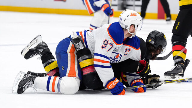 VANCOUVER, CANADA - JANUARY 18: Connor McDavid #97 of the Edmonton Oilers lays on top of Conor Garland #8 of the Vancouver Canucks during the third period of their NHL game at Rogers Arena on January 18, 2025 in Vancouver, British Columbia, Canada.