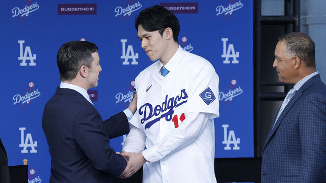 LOS ANGELES, CALIFORNIA - JANUARY 22: Pitcher Roki Sasaki (2R) shakes hands with President, Baseball Operations Andrew Friedman (2L) talk during a Los Angeles Dodgers press conference at Dodger Stadium on January 22, 2025 in Los Angeles, California.