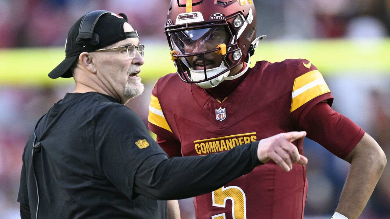 LANDOVER, MD - NOVEMBER 24: Washington Commanders head coach Dan Quinn confers with quarterback Jayden Daniels in the late in the fourth quarter during the Cowboys' defeat of the Commaders 34-26 at the Northwest Stadium in Landover, MD on November 24, 2024.