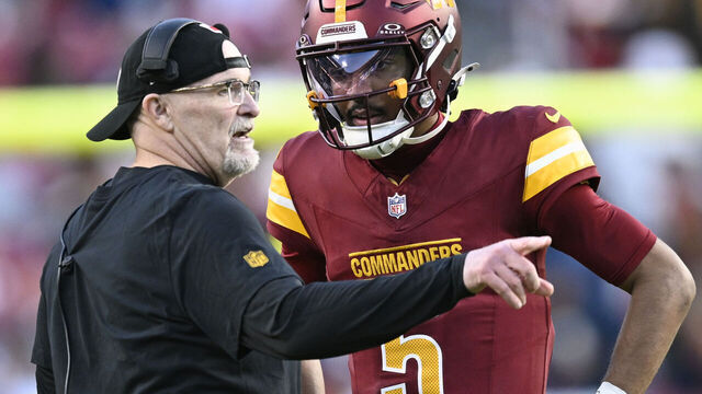 LANDOVER, MD - NOVEMBER 24: Washington Commanders head coach Dan Quinn confers with quarterback Jayden Daniels in the late in the fourth quarter during the Cowboys' defeat of the Commaders 34-26 at the Northwest Stadium in Landover, MD on November 24, 2024.
