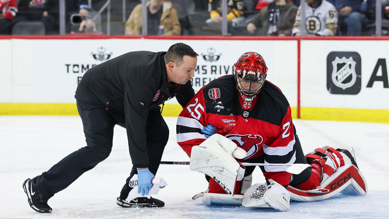 NEWARK, NJ - JANUARY 22: New Jersey Devils goaltender Jacob Markstrom (25) is attended to by the New Jersey Devils trainer after a collision with Boston Bruins right wing Justin Brazeau (55) (not pictured) during a NHL game between the Boston Bruins and New Jersey Devils at Prudential Center on January 22, 2025 in Newark, New Jersey.