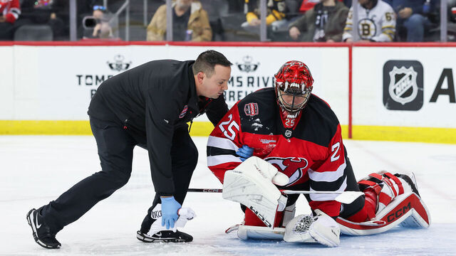 NEWARK, NJ - JANUARY 22: New Jersey Devils goaltender Jacob Markstrom (25) is attended to by the New Jersey Devils trainer after a collision with Boston Bruins right wing Justin Brazeau (55) (not pictured) during a NHL game between the Boston Bruins and New Jersey Devils at Prudential Center on January 22, 2025 in Newark, New Jersey.