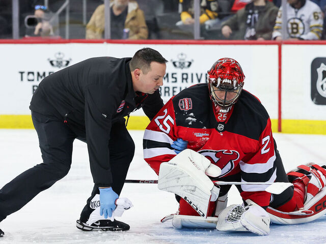 NEWARK, NJ - JANUARY 22: New Jersey Devils goaltender Jacob Markstrom (25) is attended to by the New Jersey Devils trainer after a collision with Boston Bruins right wing Justin Brazeau (55) (not pictured) during a NHL game between the Boston Bruins and New Jersey Devils at Prudential Center on January 22, 2025 in Newark, New Jersey.