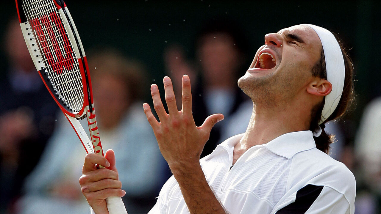 Roger Federer of Switzerland celebrates his win over Andy Roddick of the US after their mens' singles match at the 118th Wimbledon Tennis Championships in Wimbledon, London 03 July, 2004. Federer won 4-6, 7-5, 7-6, 6-4. AFP PHOTO/ODD ANDERSEN