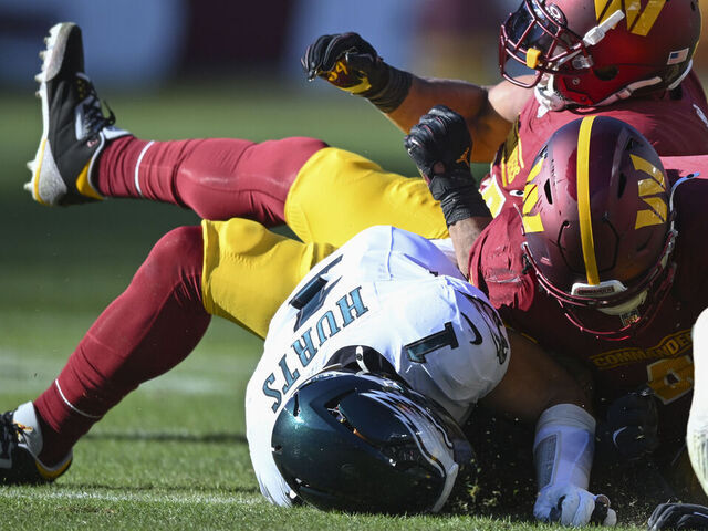 LANDOVER, MD - DECEMBER 22: Philadelphia Eagles quarterback Jalen Hurts (1) is knocked out of the game on a tackle by Washington Commanders linebacker Bobby Wagner, top and Commanders linebacker Frankie Luvu at the Northwest Stadium in Landover, MD on December 22, 2024.