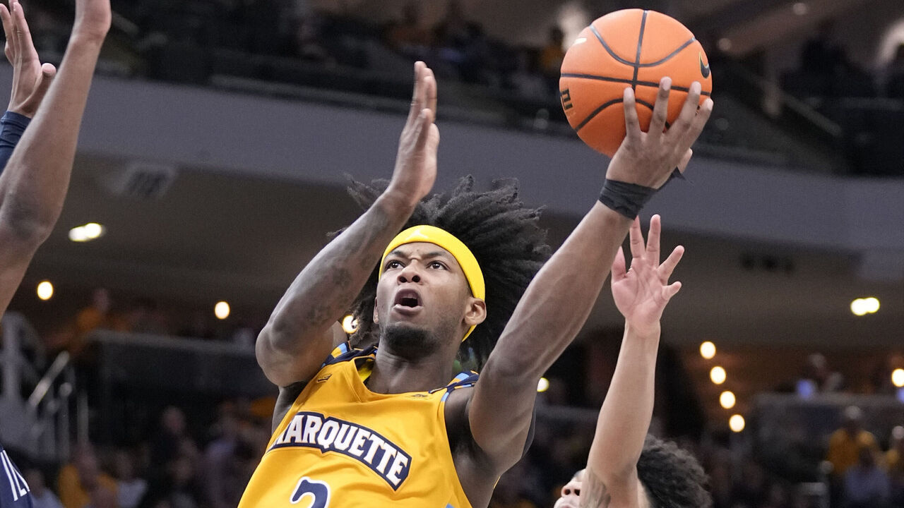 MILWAUKEE, WISCONSIN - JANUARY 24: Chase Ross #2 of the Marquette Golden Eagles scores against Jordan Longino #15 of the Villanova Wildcats (left) and Tyler Perkins #4 of the Villanova Wildcats (right) at Fiserv Forum on January 24, 2025 in Milwaukee, Wisconsin.