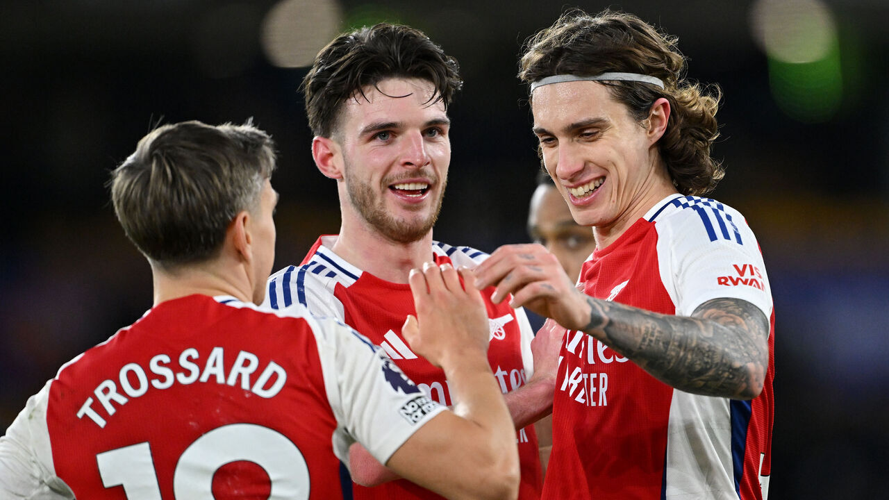 WOLVERHAMPTON, ENGLAND - JANUARY 25: Declan Rice, Riccardo Calafiori and Leandro Trossard of Arsenal celebrate victory following the Premier League match between Wolverhampton Wanderers FC and Arsenal FC at Molineux on January 25, 2025 in Wolverhampton, England.