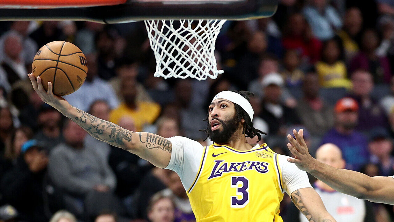 CHARLOTTE, NORTH CAROLINA - JANUARY 27: Anthony Davis #3 of the Los Angeles Lakers attempts a lay up against Taj Gibson #67 of the Charlotte Hornets during the second half of the game at Spectrum Center on January 27, 2025 in Charlotte, North Carolina.