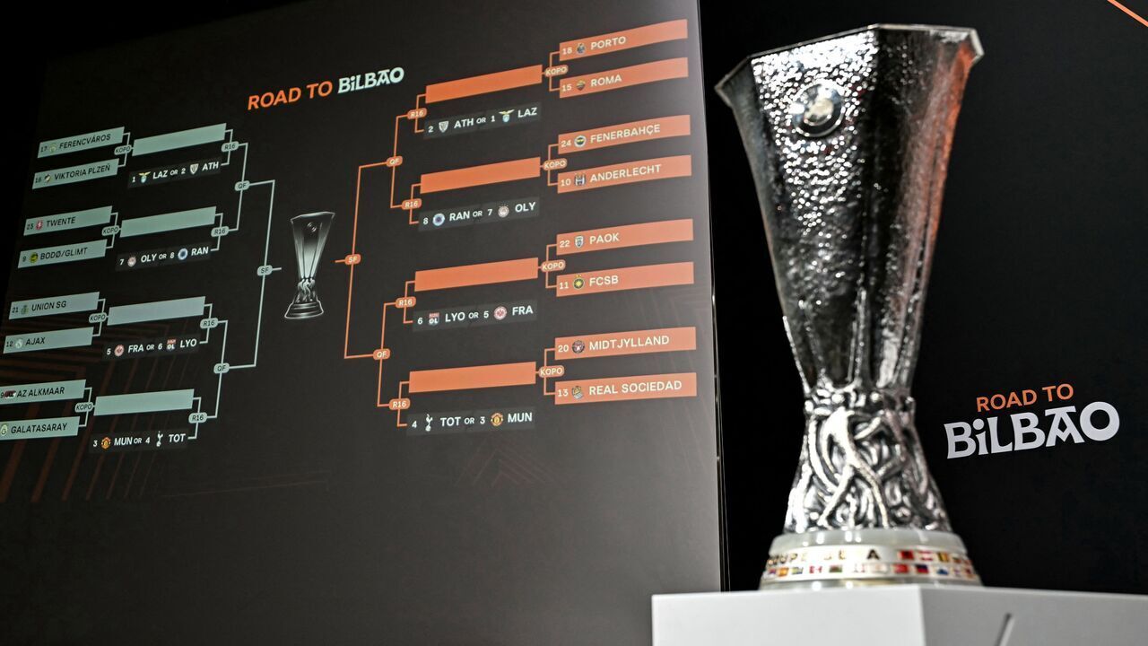 TOPSHOT - The trophy is on display next to a giant screen showing fixtures during the 2024-2025 UEFA Europa League football tournament knockout play-off draw at the House of European Football in Nyon, on January 31, 2025.