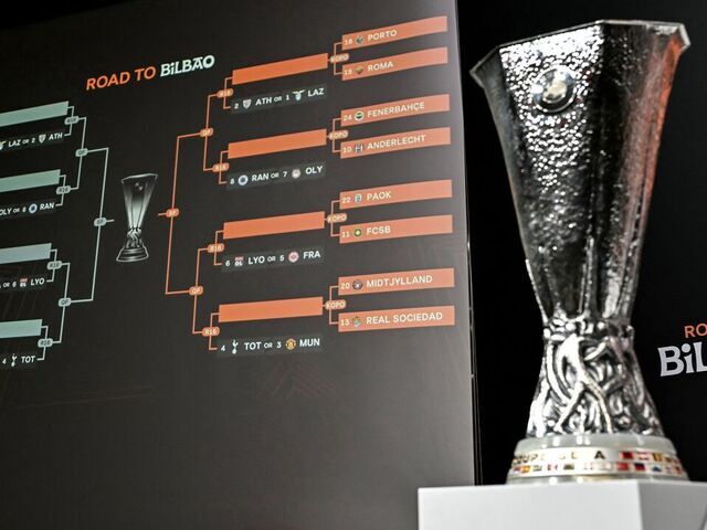 TOPSHOT - The trophy is on display next to a giant screen showing fixtures during the 2024-2025 UEFA Europa League football tournament knockout play-off draw at the House of European Football in Nyon, on January 31, 2025.