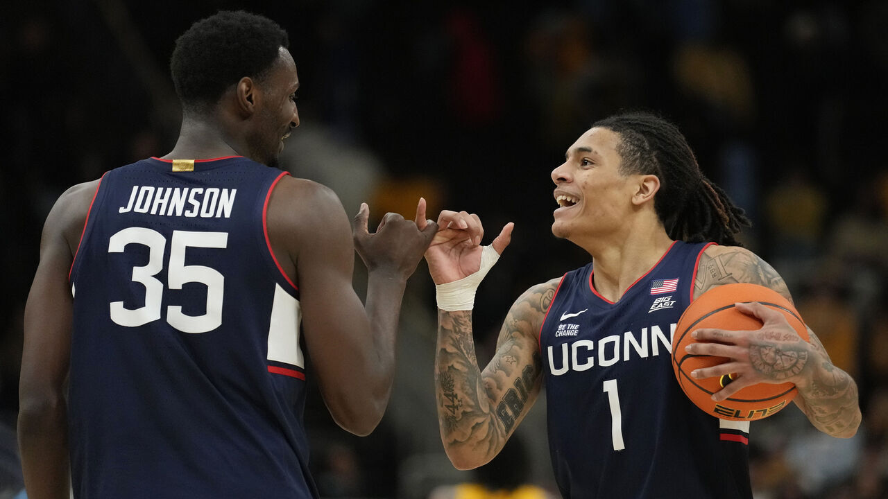 MILWAUKEE, WISCONSIN - FEBRUARY 01: Samson Johnson #35 and Solo Ball #1 of the Connecticut Huskies celebrate after defeating the Marquette Golden Eagles 77-69 at Fiserv Forum on February 01, 2025 in Milwaukee, Wisconsin.