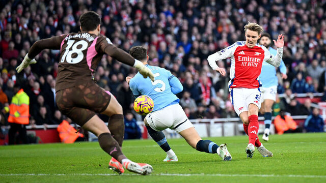 LONDON, ENGLAND - FEBRUARY 02: Martin Odegaard of Arsenal scores his team's first goal whilst under pressure from John Stones of Manchester City as Stefan Ortega of Manchester City fails to make a save during the Premier League match between Arsenal FC and Manchester City FC at Emirates Stadium on February 02, 2025 in London, England.