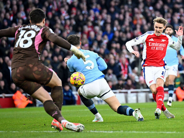 LONDON, ENGLAND - FEBRUARY 02: Martin Odegaard of Arsenal scores his team's first goal whilst under pressure from John Stones of Manchester City as Stefan Ortega of Manchester City fails to make a save during the Premier League match between Arsenal FC and Manchester City FC at Emirates Stadium on February 02, 2025 in London, England.