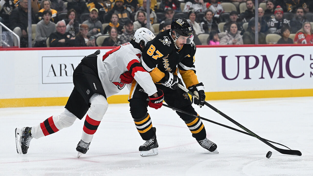 PITTSBURGH, PENNSYLVANIA - FEBRUARY 4: Sidney Crosby #87 of the Pittsburgh Penguins skates with the puck against Luke Hughes #43 of the New Jersey Devils in the first period at PPG PAINTS Arena on February 4, 2025 in Pittsburgh, Pennsylvania.
