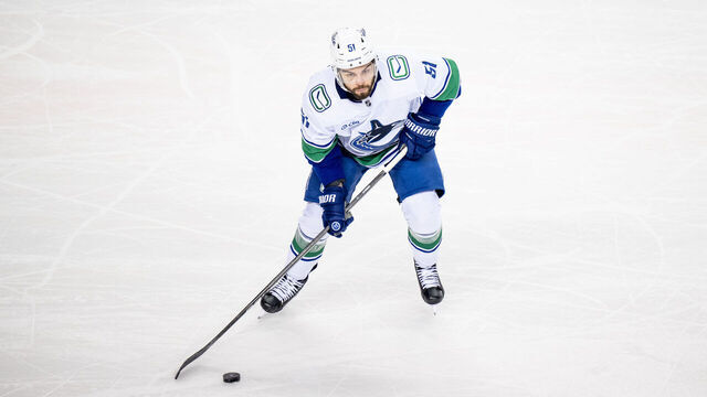 CALGARY, AB - SEPTEMBER 28: Vancouver Canucks Defenceman Mark Friedman (51) skates with the puck during the first period of an NHL preseason game between the Calgary Flames and the Vancouver Canucks on September 28, 2024, at the Scotiabank Saddledome in Calgary, AB.