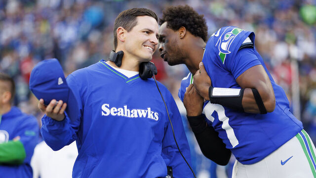 SEATTLE, WASHINGTON - OCTOBER 10: Quarterback Geno Smith #7 of the Seattle Seahawks and head coach Mike Macdonald interact on the sidelines prior to an NFL football game against the San Francisco 49ers, at Lumen Field on October 10, 2024 in Seattle, Washington.