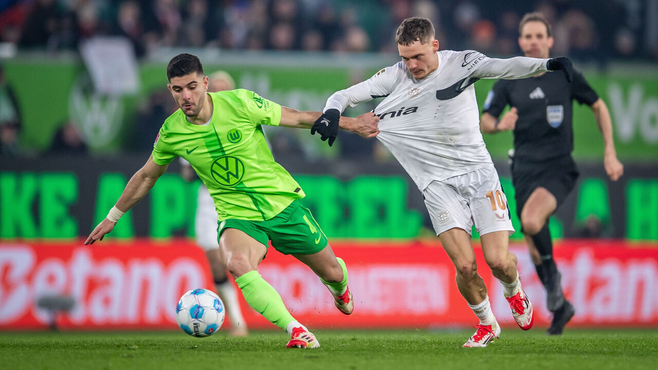 WOLFSBURG, GERMANY - FEBRUARY 08: Konstantinos Koulierakis of VfL Wolfsburg battles for possession with Florian Wirtz of Bayer 04 Leverkusen during the Bundesliga match between VfL Wolfsburg and Bayer 04 Leverkusen at Volkswagen Arena on February 08, 2025 in Wolfsburg, Germany.