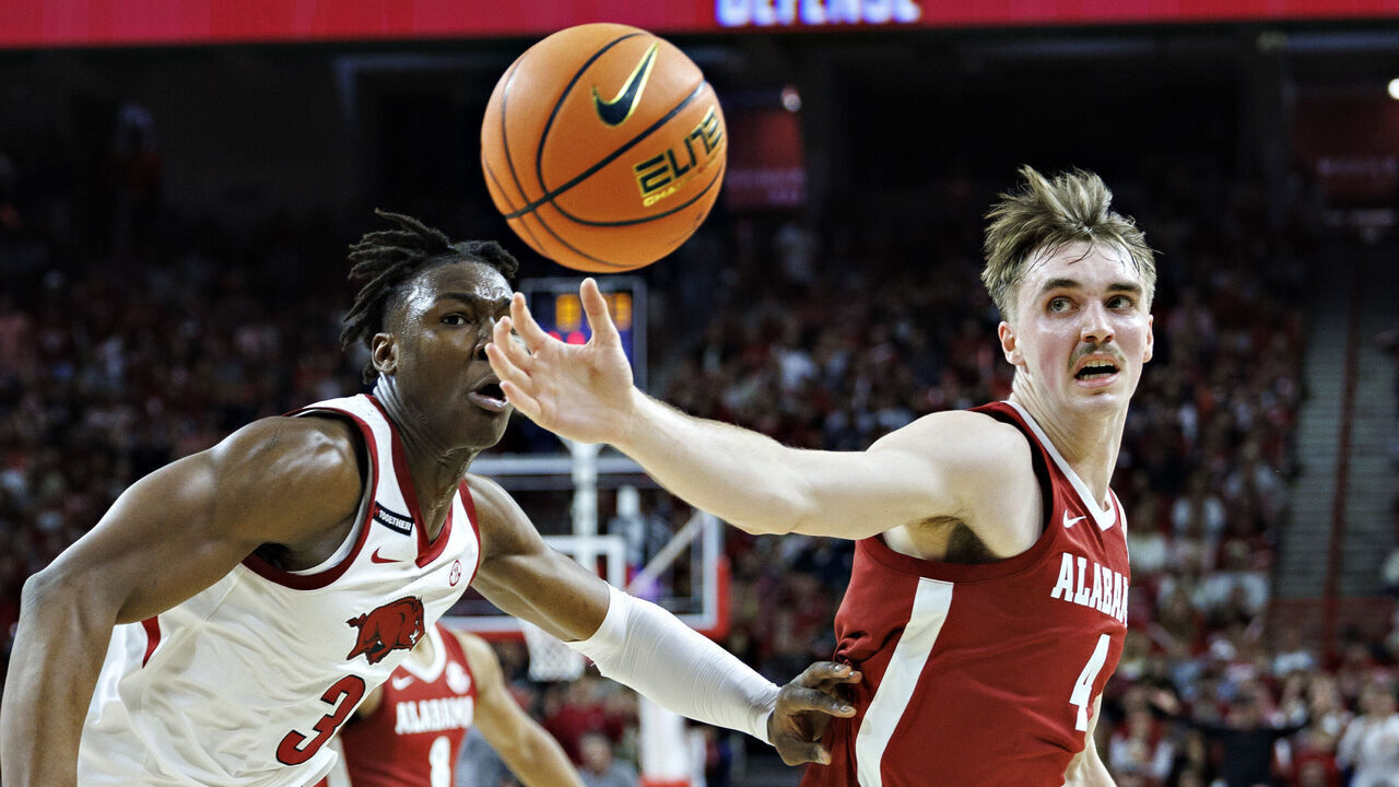 FAYETTEVILLE, ARKANSAS - FEBRUARY 08: Grant Nelson #4 of the Alabama Crimson Tide goes for a loose ball against Adou Thiero #3 of the Arkansas Razorbacks at Bud Walton Arena on February 08, 2025 in Fayetteville, Arkansas.