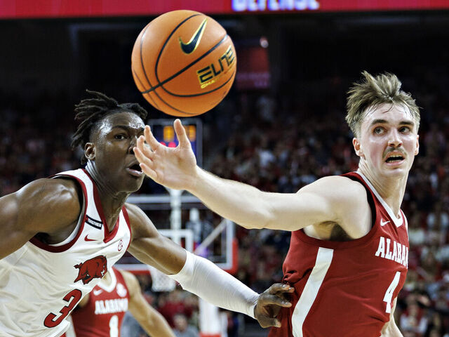 FAYETTEVILLE, ARKANSAS - FEBRUARY 08: Grant Nelson #4 of the Alabama Crimson Tide goes for a loose ball against Adou Thiero #3 of the Arkansas Razorbacks at Bud Walton Arena on February 08, 2025 in Fayetteville, Arkansas.