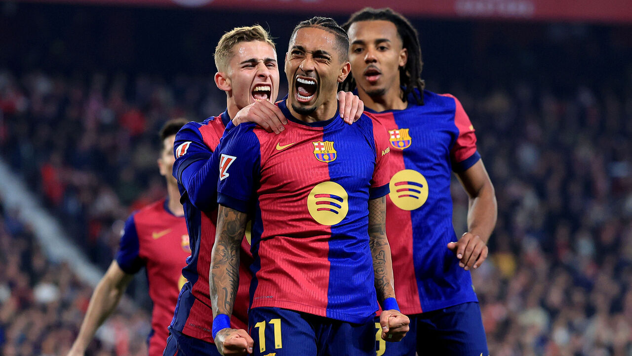 SEVILLE, SPAIN - FEBRUARY 09: Raphinha of FC Barcelona celebrates scoring his team's third goal with teammates Fermin Lopez and Jules Kounde during the LaLiga match between Sevilla FC and FC Barcelona at Estadio Ramon Sanchez Pizjuan on February 09, 2025 in Seville, Spain.