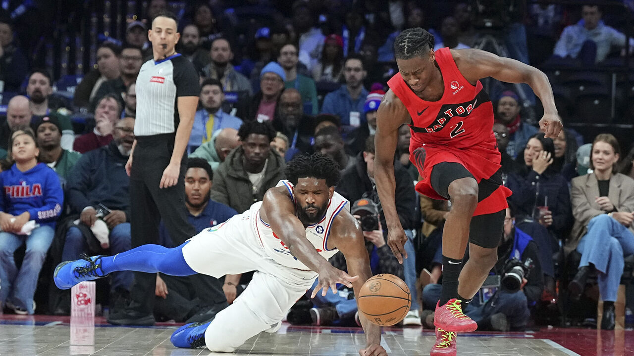 PHILADELPHIA, PENNSYLVANIA - FEBRUARY 11: Joel Embiid #21 of the Philadelphia 76ers dives for the ball against Jonathan Mogbo #2 of the Toronto Raptors in the second half at the Wells Fargo Center on February 11, 2025 in Philadelphia, Pennsylvania. The Raptors defeated the 76ers 106-103. NOTE TO USER: User expressly acknowledges and agrees that, by downloading and/or using this photograph, user is consenting to the terms and conditions of the Getty Images License Agreement.