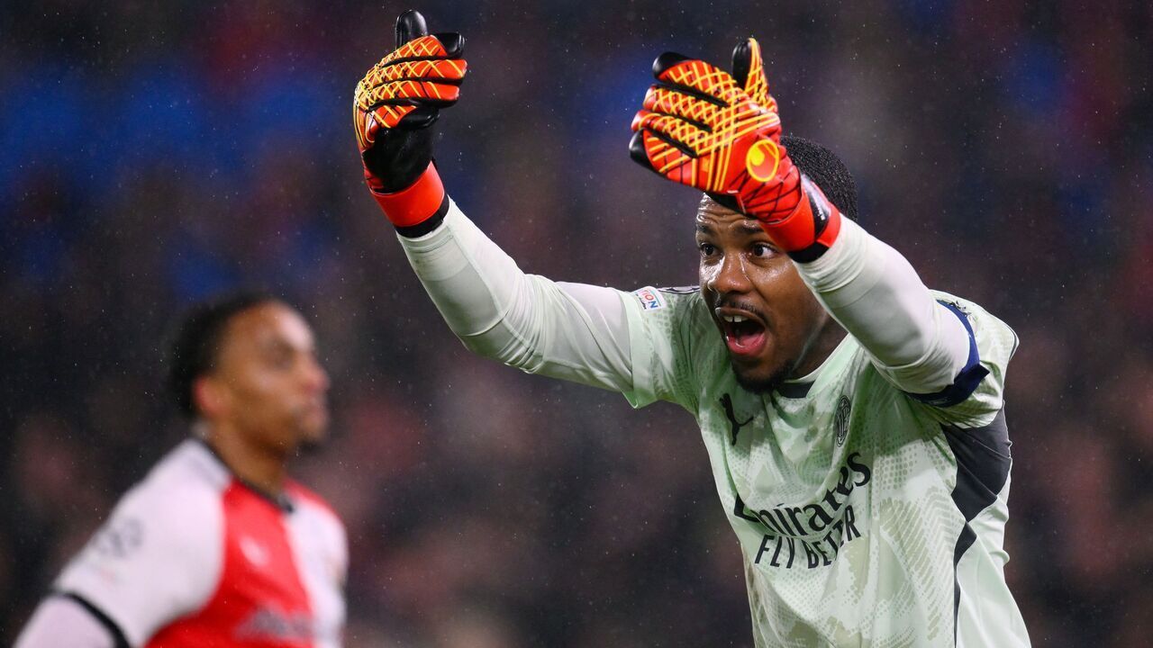 AC Milan's French goalkeeper #16 Mike Maignan reacts during the UEFA Champions League knockout phase play-off 1st leg football match between Feyenoord Rotterdam and AC Milan at the Stadion Feijenoord "De Kuip" in Rotterdam, on February 12, 2025.