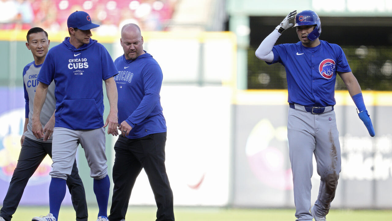CINCINNATI, OHIO - JUNE 07: Craig Counsell #30 of the Chicago Cubs speaks with Seiya Suzuki #27 after he was injured stealing second base during the first inning of a baseball game against the Cincinnati Reds at Great American Ball Park on June 07, 2024 in Cincinnati, Ohio.