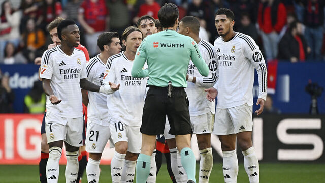 TOPSHOT - Real Madrid's players remonstrate with Spanish referee Munuera Montero about the red card presented to Real Madrid's English midfielder #05 Jude Bellingham (R) during the Spanish league football match between CA Osasuna and Real Madrid CF at El Sadar Stadium in Pamplona on February 15, 2025.