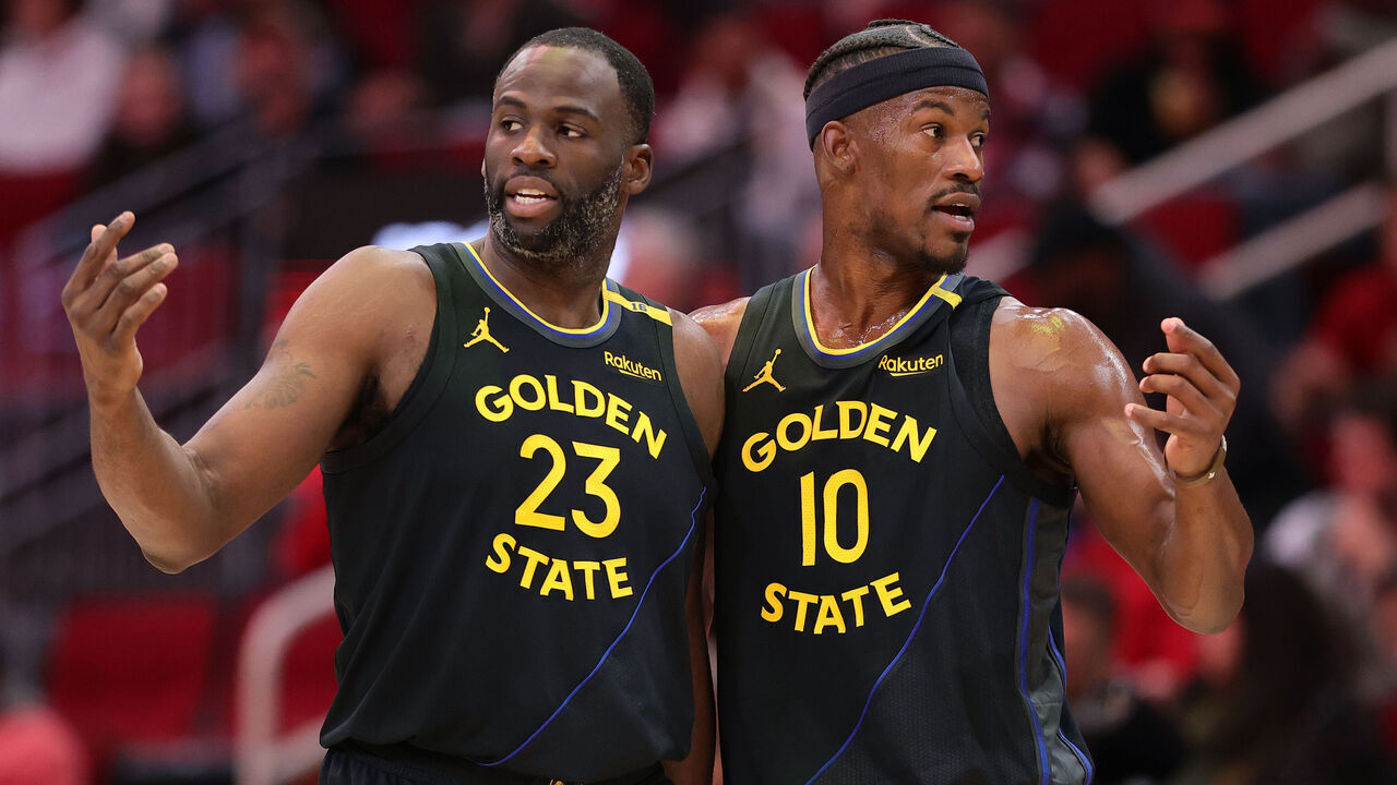 HOUSTON, TEXAS - FEBRUARY 13: Draymond Green #23 and Jimmy Butler #10 of the Golden State Warriors speak on the court against the Houston Rockets during the first half at Toyota Center on February 13, 2025 in Houston, Texas.