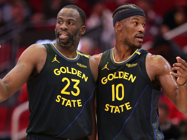 HOUSTON, TEXAS - FEBRUARY 13: Draymond Green #23 and Jimmy Butler #10 of the Golden State Warriors speak on the court against the Houston Rockets during the first half at Toyota Center on February 13, 2025 in Houston, Texas.