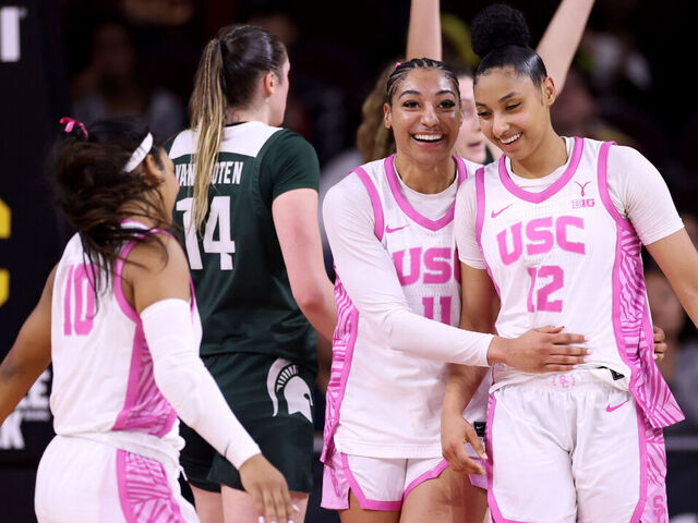LOS ANGELES, CALIFORNIA - FEBRUARY 19: JuJu Watkins #12 of the USC Trojans laughs with Kennedy Smith #11 after a Michigan State Spartans foul during the first half at Galen Center on February 19, 2025 in Los Angeles, California.