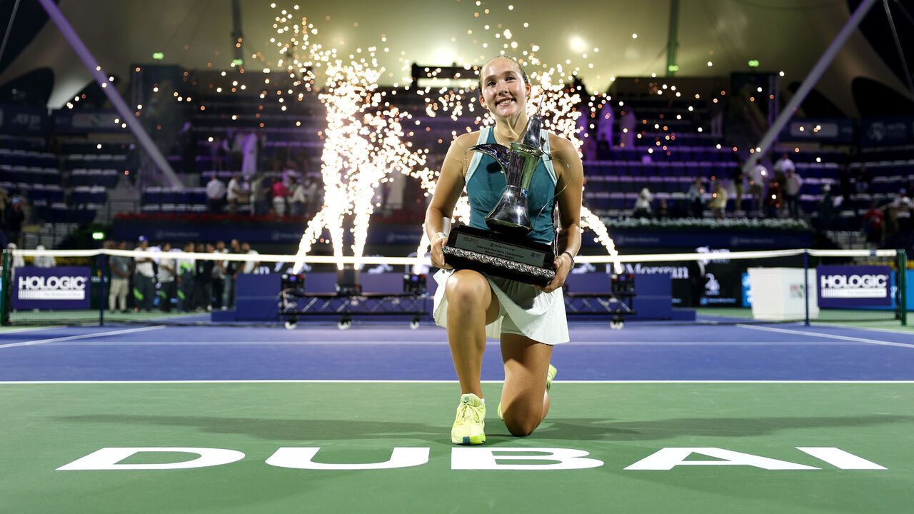 DUBAI, UNITED ARAB EMIRATES - FEBRUARY 22: Mirra Andreeva celebrates with the trophy after victory over Clara Tauson of Denmark in the final during day seven of the Dubai Duty Free Tennis Championships, part of the Hologic WTA Tour at Dubai Duty Free Tennis Stadium on February 22, 2025 in Dubai, United Arab Emirates.