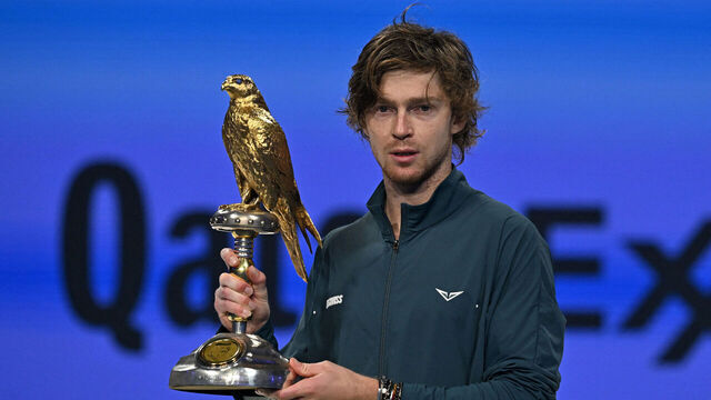 Russia's Andrey Rublev poses with the trophy on the podium after winning the ATP Qatar Open tennis tournament final match in Doha on February 22, 2025.